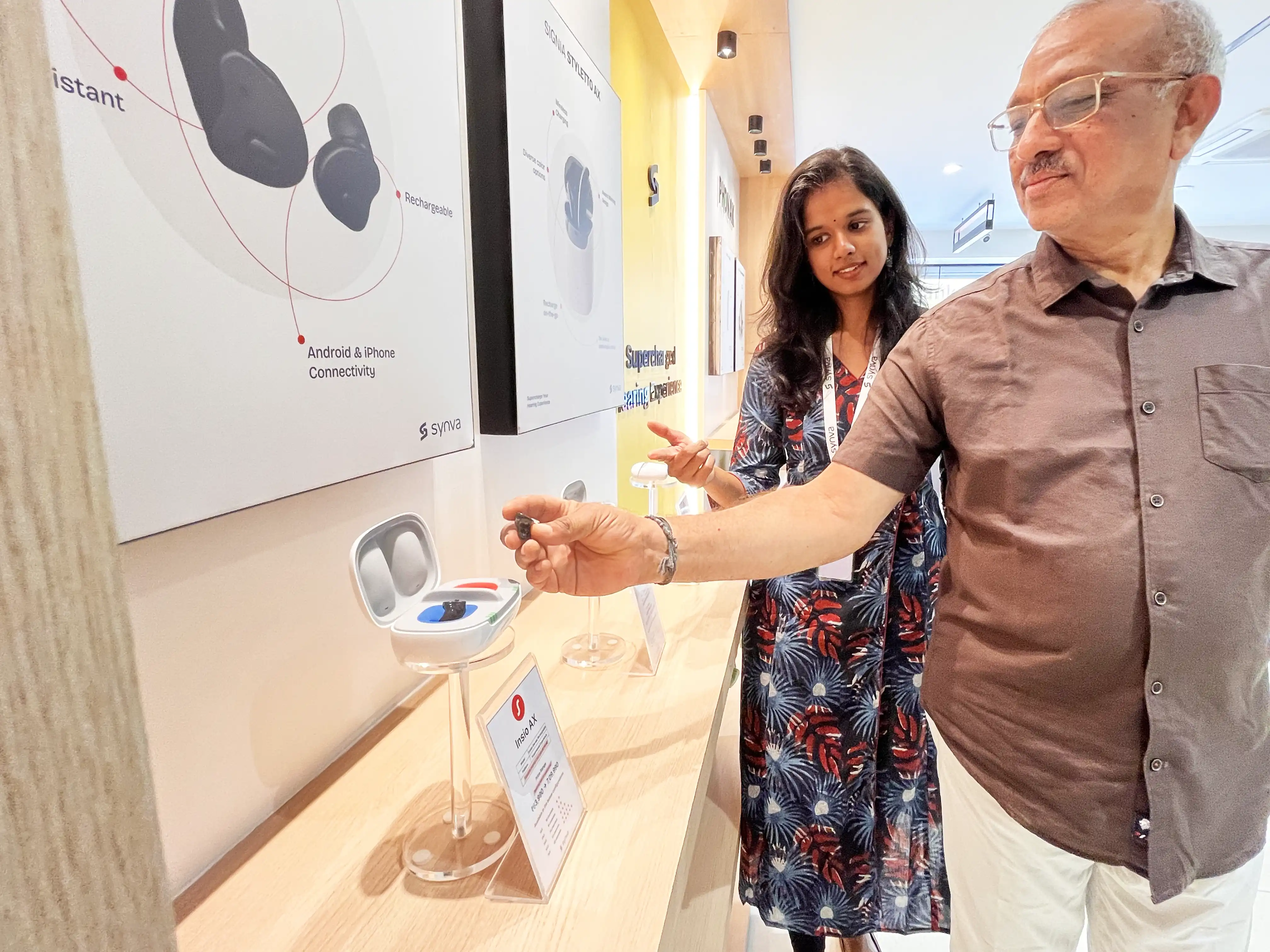 A visitor exploring hearing aids on the open product wall at the Synva Experience Centre