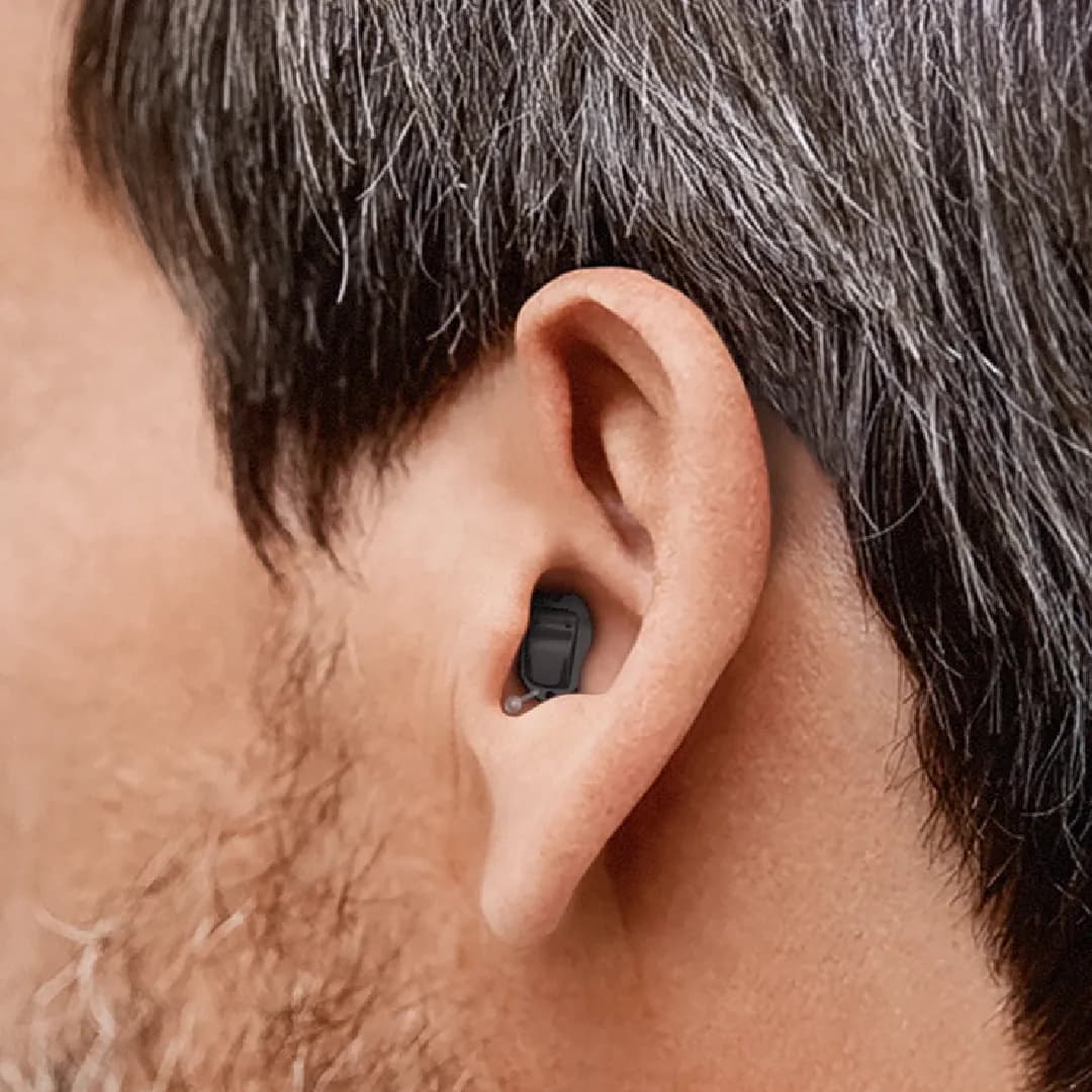 Invisible in canal hearing aids (IIC) worn by a person, cosmetic view shows of how the hearing aid is fitting